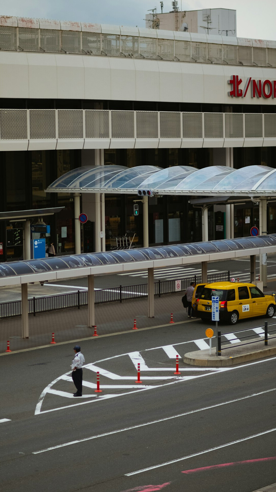 Travelers waiting in a taxi queue outside a terminal