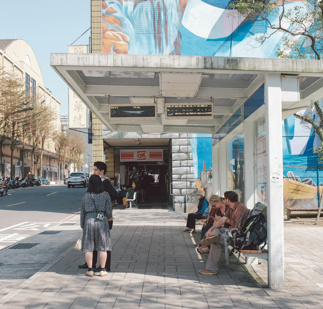 people waiting at busy bus stop