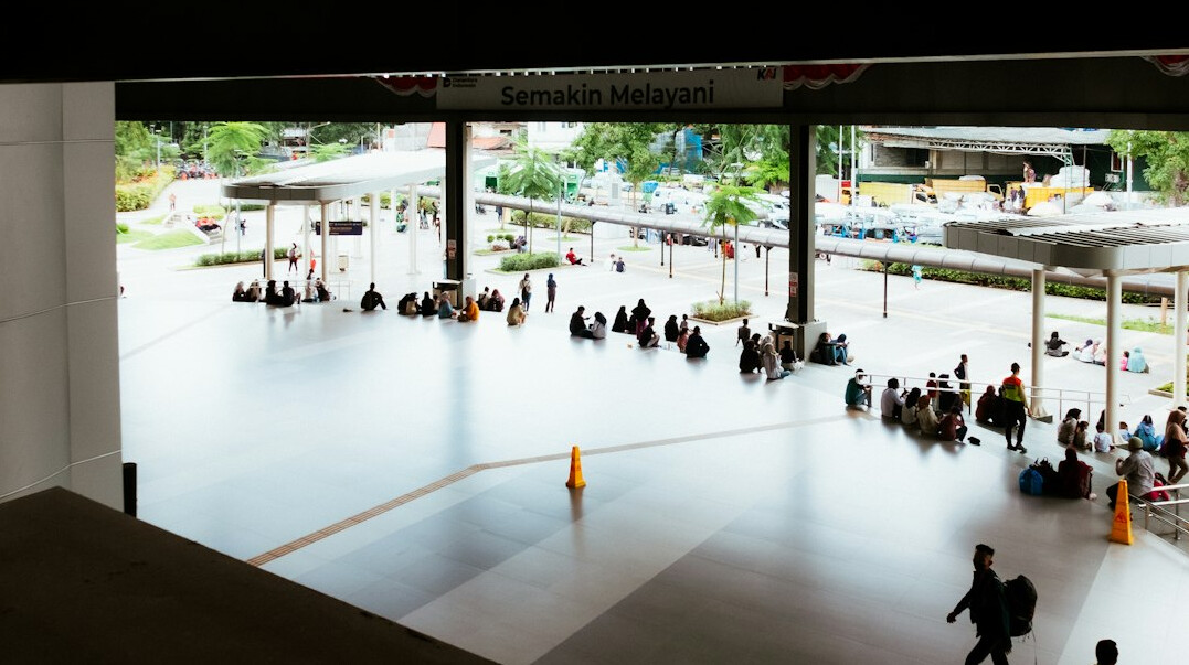 Commuters waiting inside a busy transit station concourse