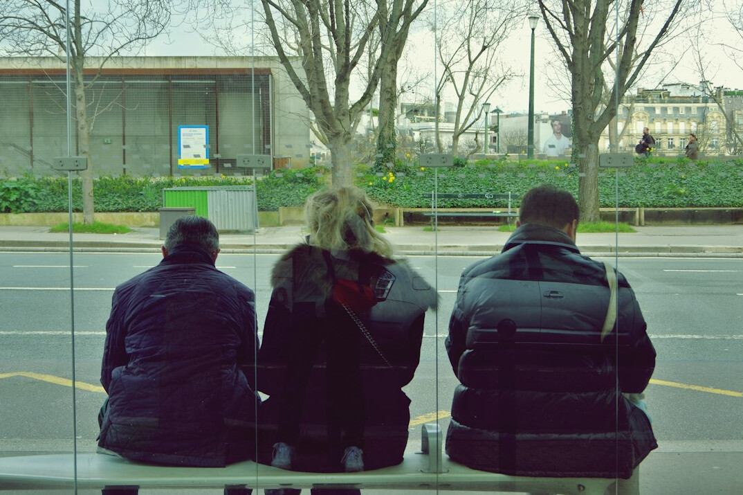 people waiting at bus stop in city