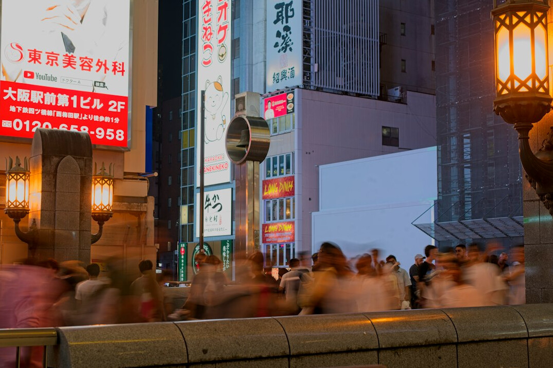 crowd of people waiting at busy intersection