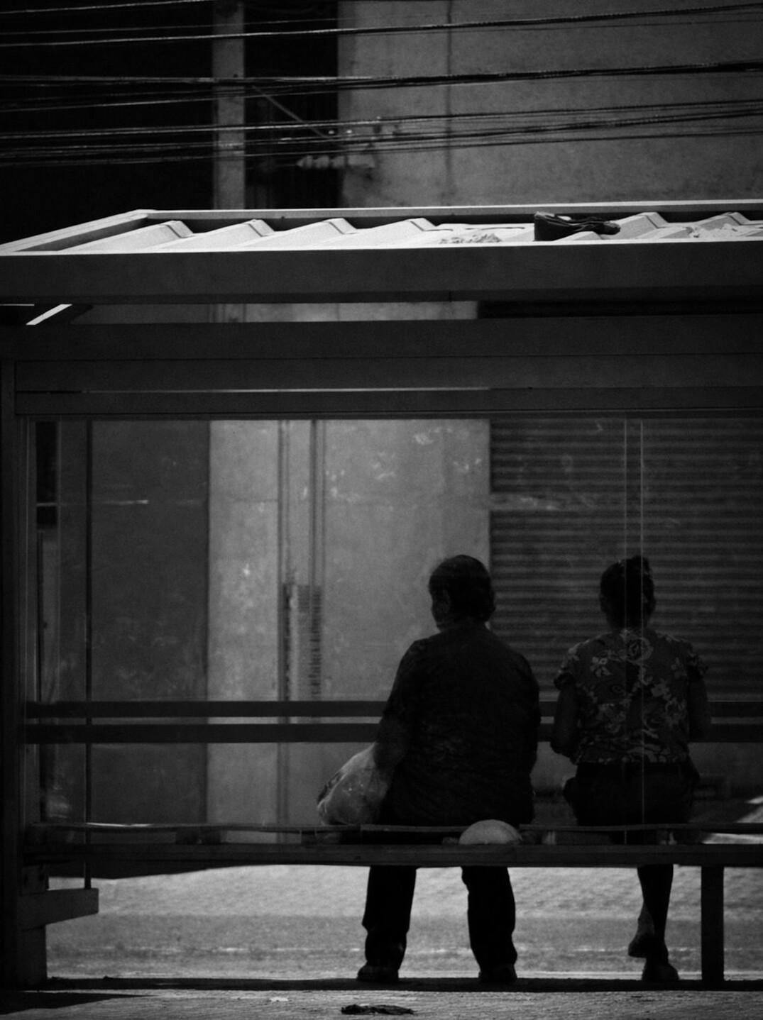 Commuters waiting under a city bus shelter