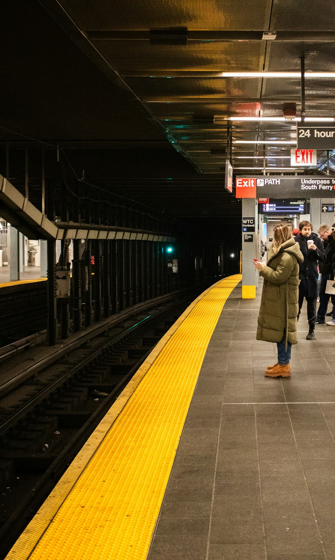 Passengers standing on a subway platform waiting for a train